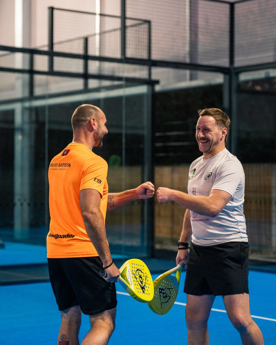Padel players fist bumping after a point at a sponsor match on the Wirral